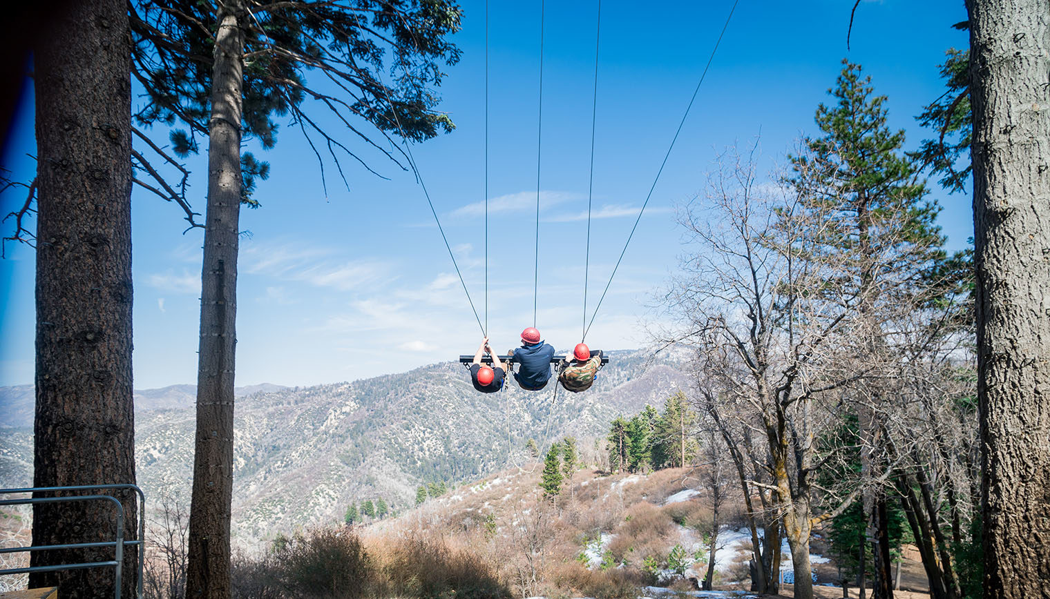A triple swing overlooking a view of mountains.