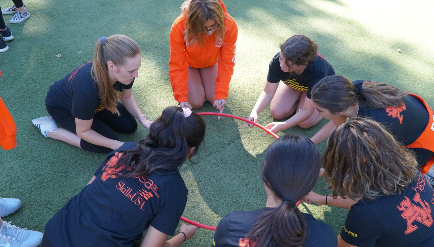 A group of people huddled together for a teambuilding activity.